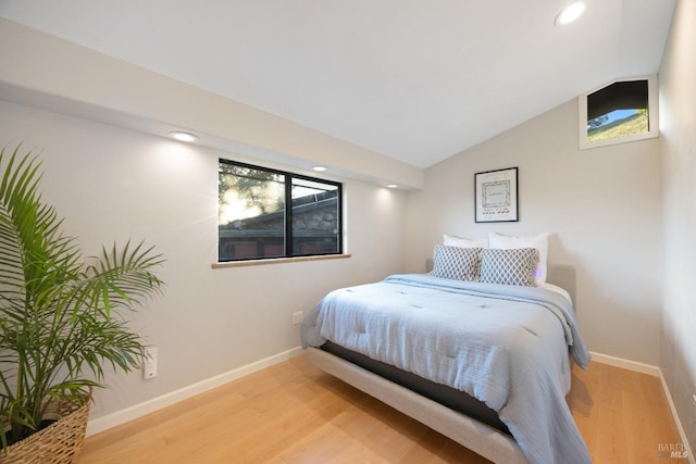 bedroom featuring light wood-type flooring, recessed lighting, baseboards, and vaulted ceiling