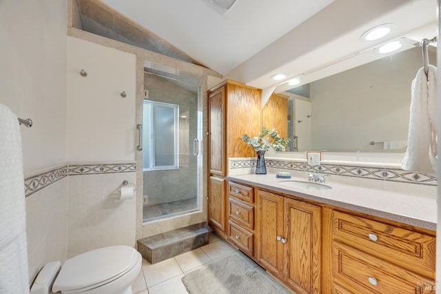 bathroom with tile patterned flooring, vaulted ceiling, a stall shower, vanity, and toilet