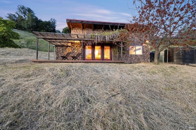 back of property featuring stone siding