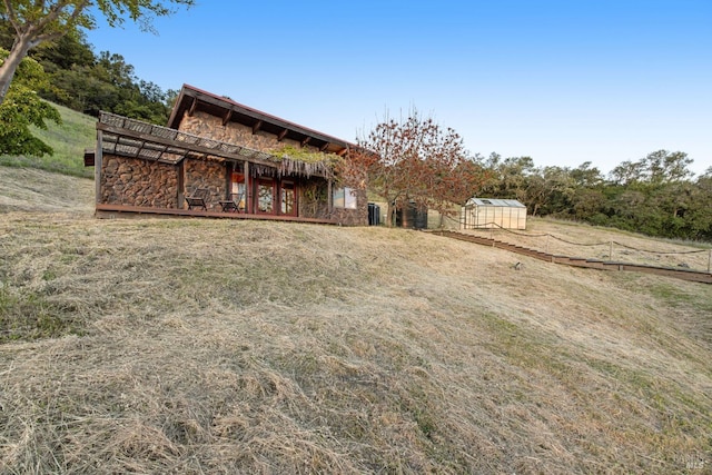 exterior space featuring an outbuilding and stone siding