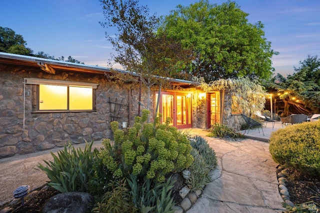 exterior space featuring a patio and stone siding