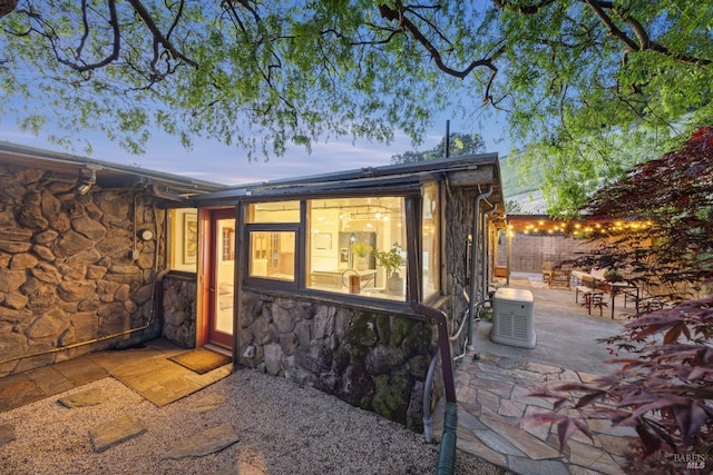 back of house featuring a patio area and stone siding