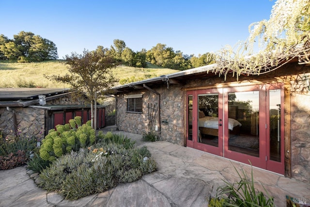 exterior space with french doors and stone siding