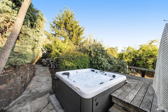 exterior space featuring an outdoor hot tub and a deck
