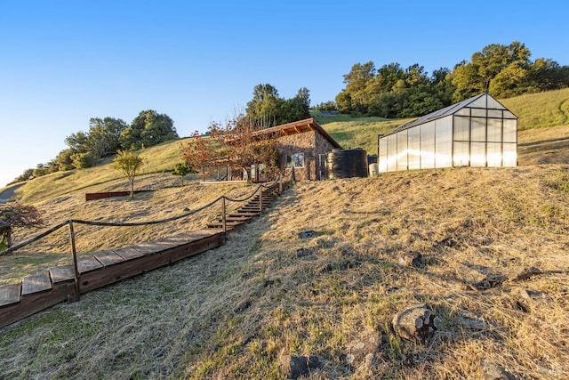 view of yard featuring an exterior structure, a rural view, and an outbuilding