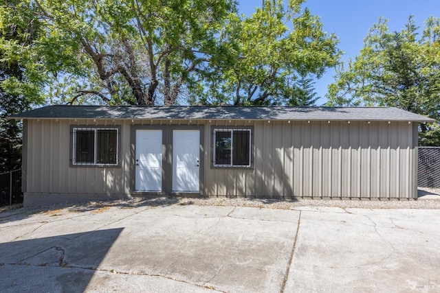 exterior space with a patio area and roof with shingles