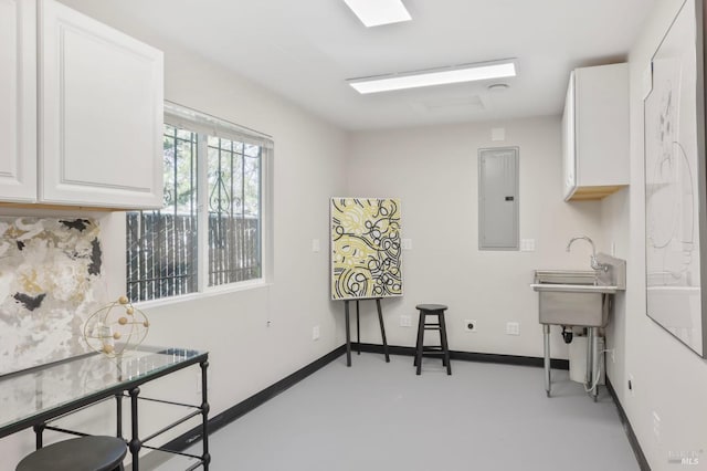 interior space with baseboards and electric panel