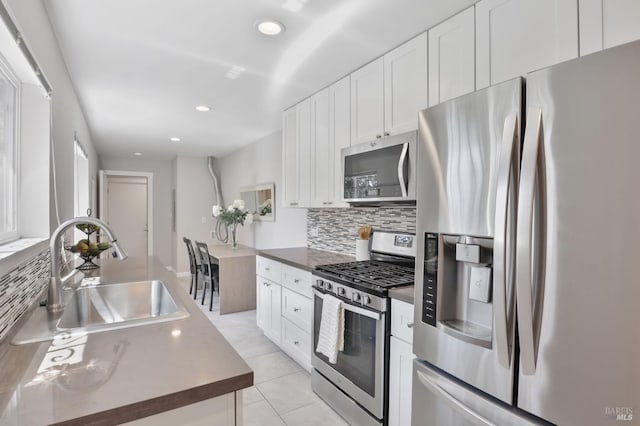 kitchen featuring a sink, white cabinetry, appliances with stainless steel finishes, and tasteful backsplash