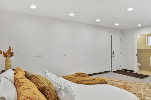 bedroom with connected bathroom and recessed lighting
