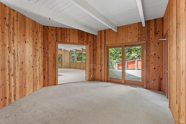 carpeted empty room with wooden walls, beam ceiling, and visible vents