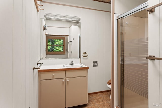 full bathroom featuring vanity, wood walls, toilet, and a shower stall