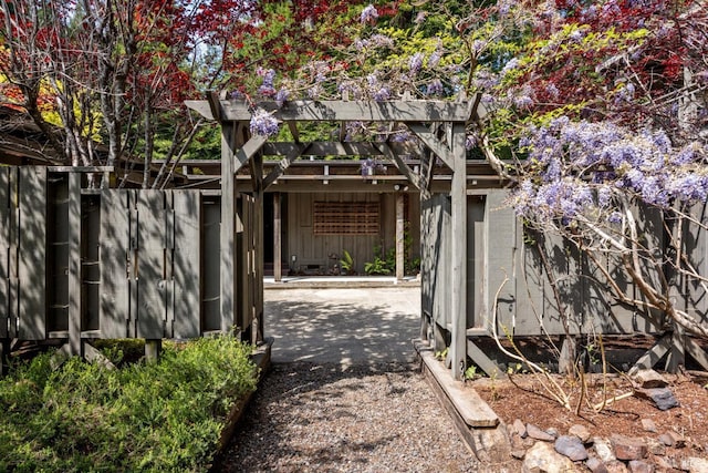 view of side of home featuring fence, a patio, and a pergola