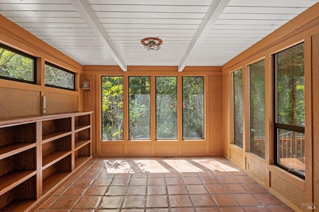 unfurnished sunroom featuring plenty of natural light and beam ceiling