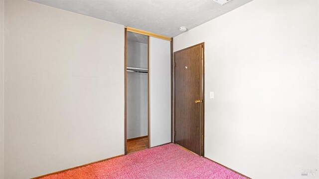 unfurnished bedroom featuring carpet and a closet