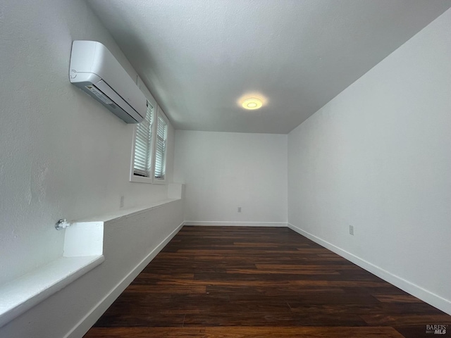 bonus room featuring baseboards, a wall mounted AC, and wood finished floors
