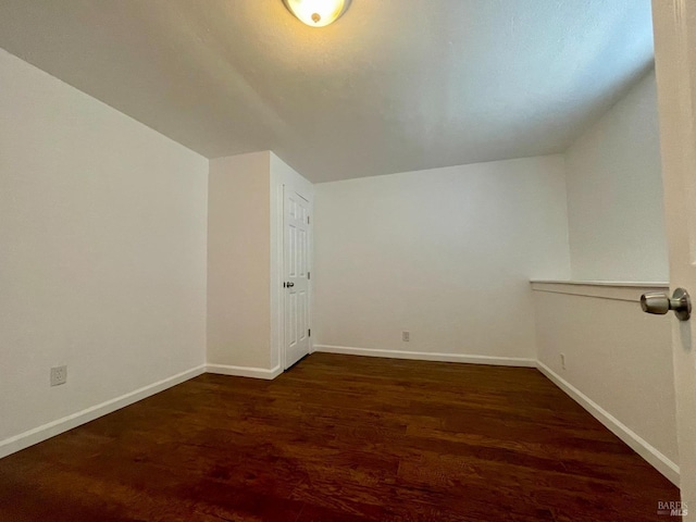 bonus room with baseboards, lofted ceiling, and wood finished floors