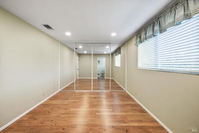 spare room featuring visible vents, recessed lighting, baseboards, and wood finished floors