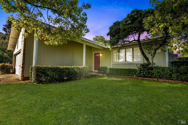 view of front of property with an attached garage and a front lawn