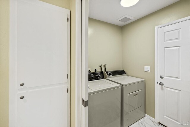 clothes washing area with washer and dryer, laundry area, and marble finish floor