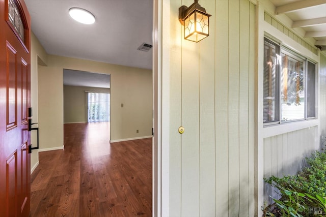 interior space featuring baseboards, dark wood-type flooring, and visible vents