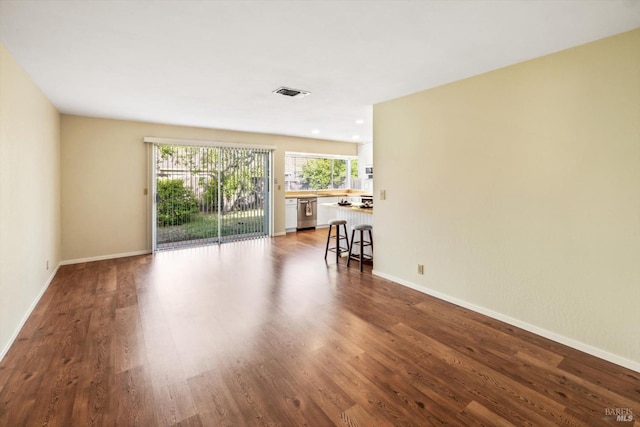 living area featuring baseboards, dark wood-type flooring, and visible vents