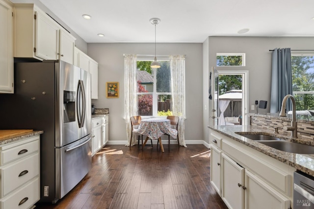 kitchen with baseboards, appliances with stainless steel finishes, dark wood-style floors, and a sink