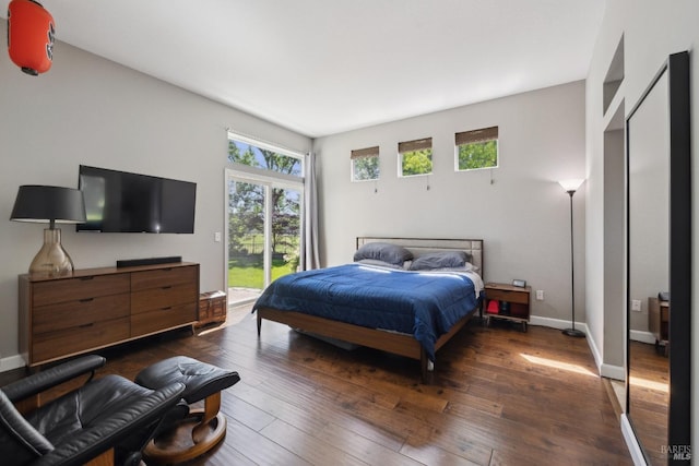 bedroom featuring dark wood-style flooring, access to outside, and baseboards