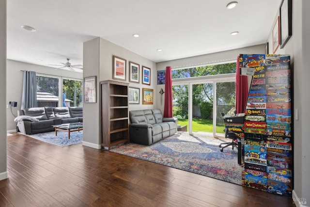 sitting room featuring baseboards, a ceiling fan, wood finished floors, and a wealth of natural light