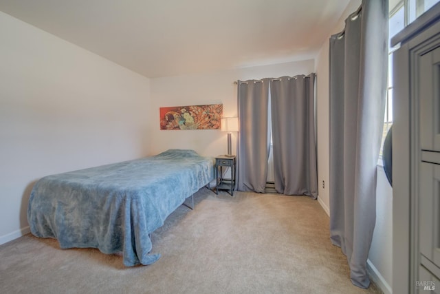 bedroom with baseboards, multiple windows, and light carpet