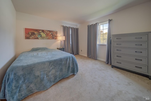 bedroom featuring baseboards and light carpet