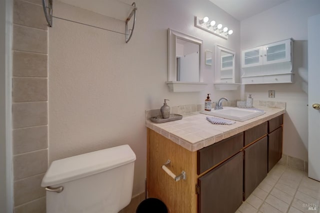 bathroom featuring toilet, tile patterned flooring, and vanity