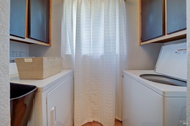 clothes washing area featuring cabinet space and washer / dryer
