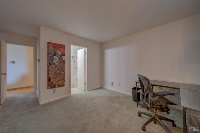 office space with baseboards and light carpet
