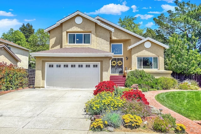 traditional-style house with stucco siding, a garage, driveway, and fence