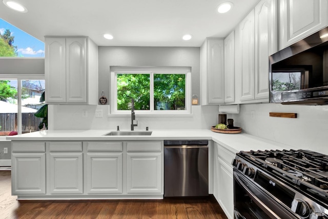 kitchen featuring stainless steel appliances, a wealth of natural light, a sink, white cabinetry, and light countertops