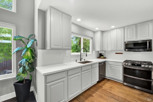 kitchen featuring a sink, appliances with stainless steel finishes, white cabinetry, and recessed lighting