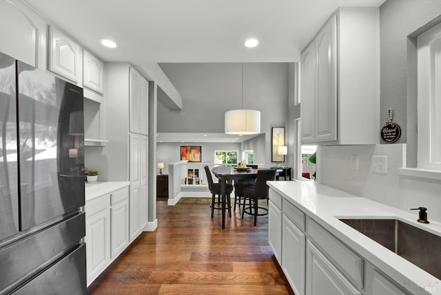 kitchen with freestanding refrigerator, a sink, light countertops, dark wood-style flooring, and recessed lighting