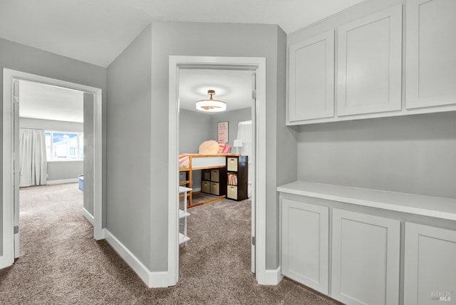 hall with carpet flooring and baseboards