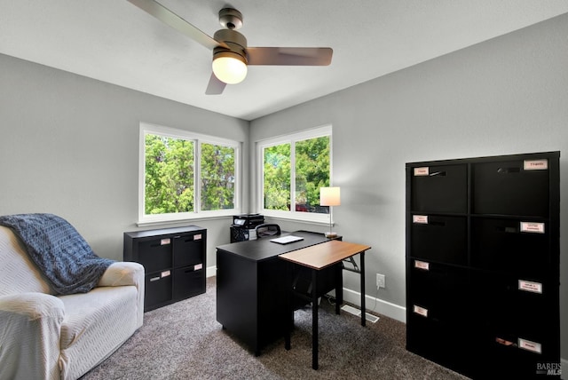 carpeted office space featuring ceiling fan and baseboards
