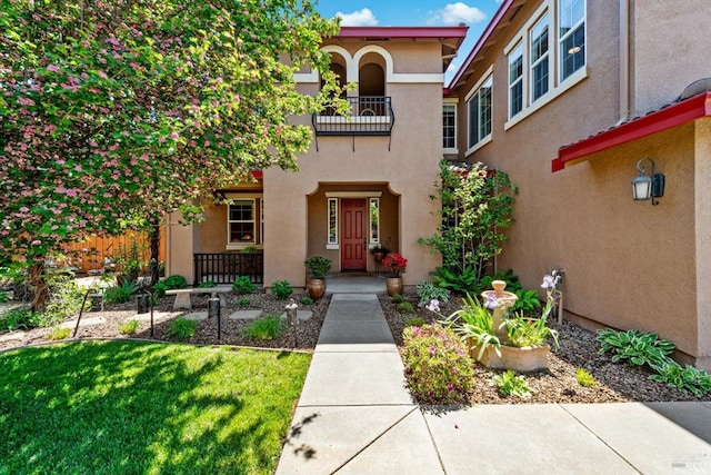 property entrance with a yard and stucco siding