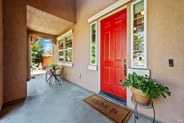 property entrance with stucco siding and a porch