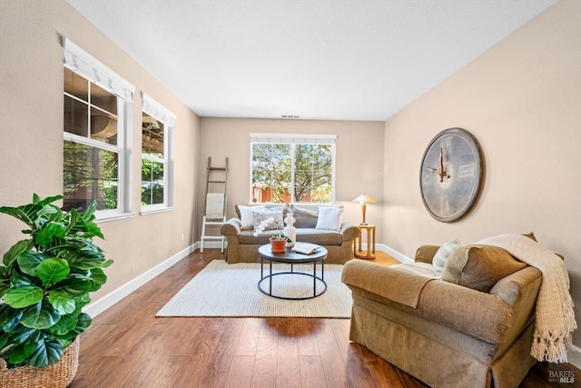 living area featuring baseboards and wood finished floors