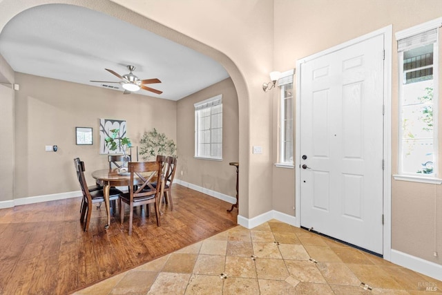 dining area with arched walkways, baseboards, and a healthy amount of sunlight