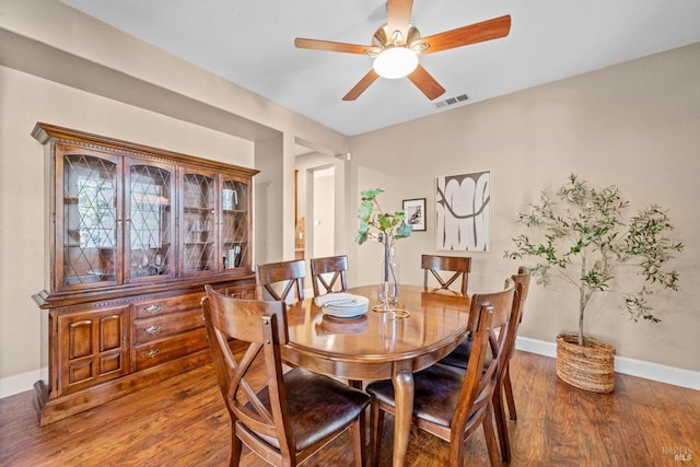 dining room with ceiling fan, baseboards, visible vents, and wood finished floors
