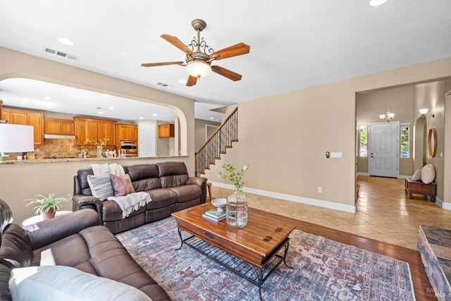 living area featuring visible vents, a ceiling fan, tile patterned flooring, recessed lighting, and arched walkways