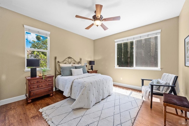bedroom with a ceiling fan, baseboards, and wood finished floors