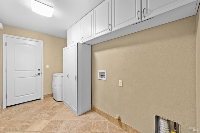 laundry room featuring cabinet space, washer hookup, a textured wall, and baseboards