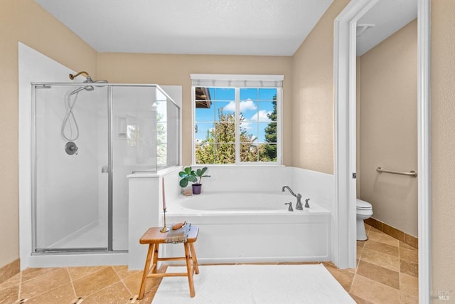 bathroom featuring a stall shower, toilet, and a garden tub