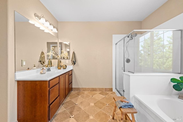 bathroom with vanity, baseboards, a bath, and a stall shower