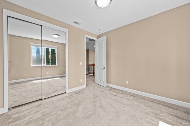 unfurnished bedroom featuring visible vents, carpet, baseboards, and a closet